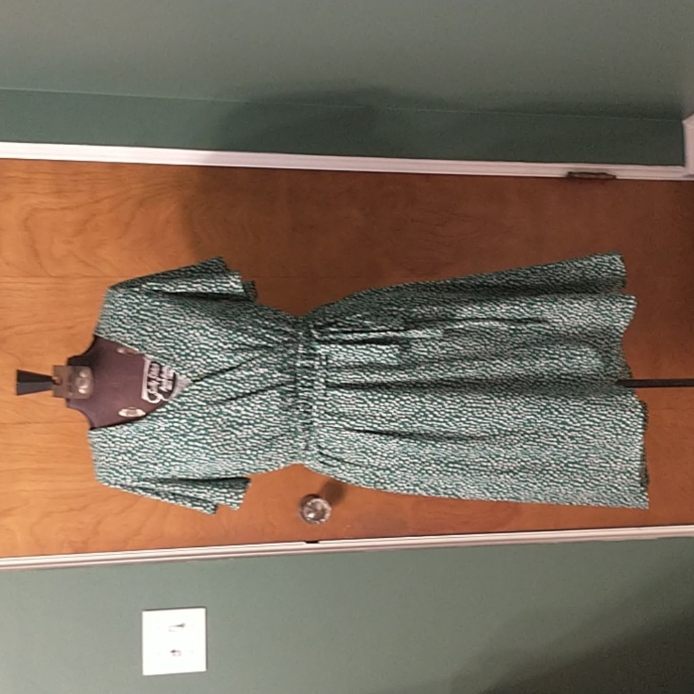 Green faux wrap dress with high low skirt and polka dots